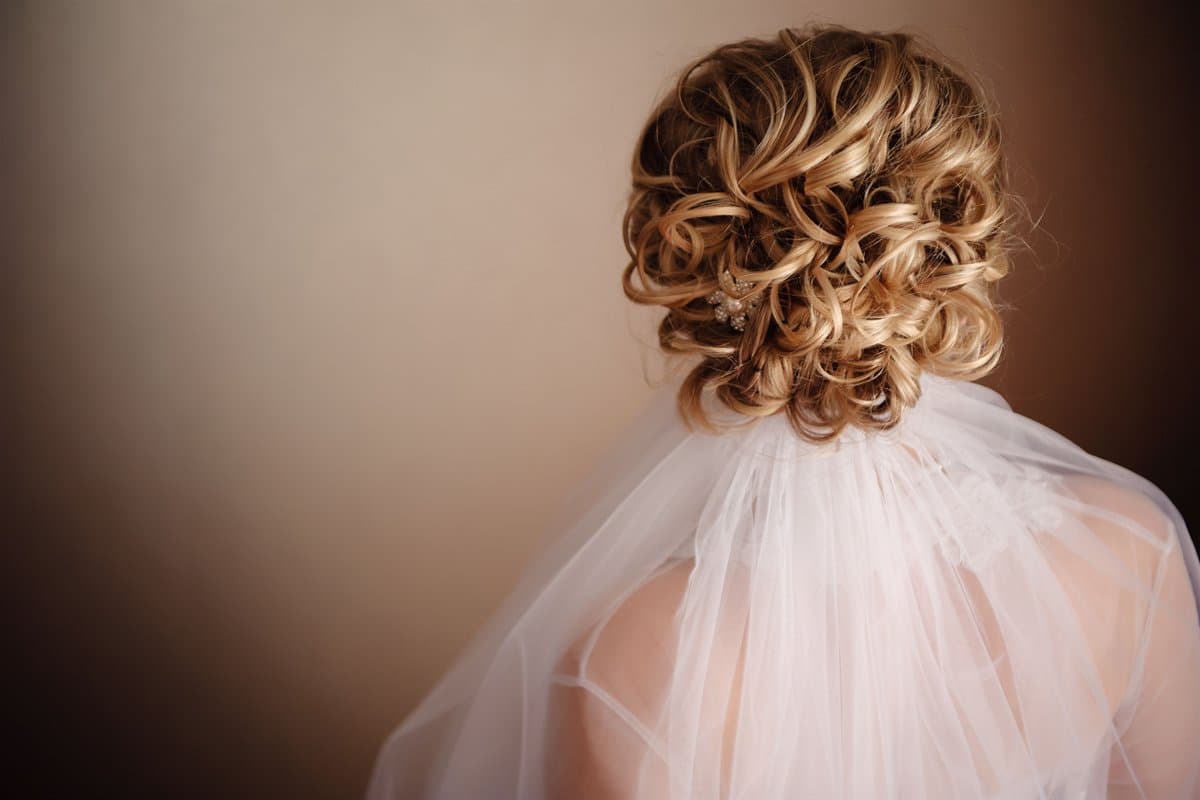 A soft curled bridal updo with veil