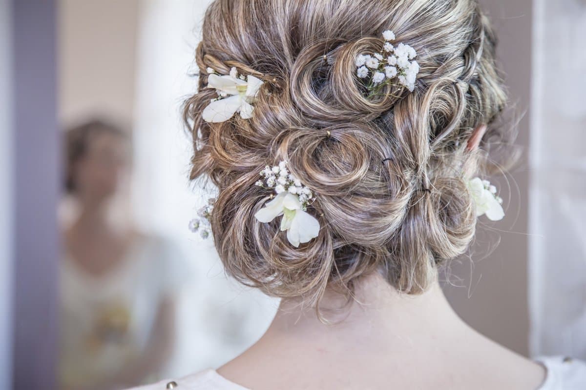 A bridal updo finished with delicate flowers