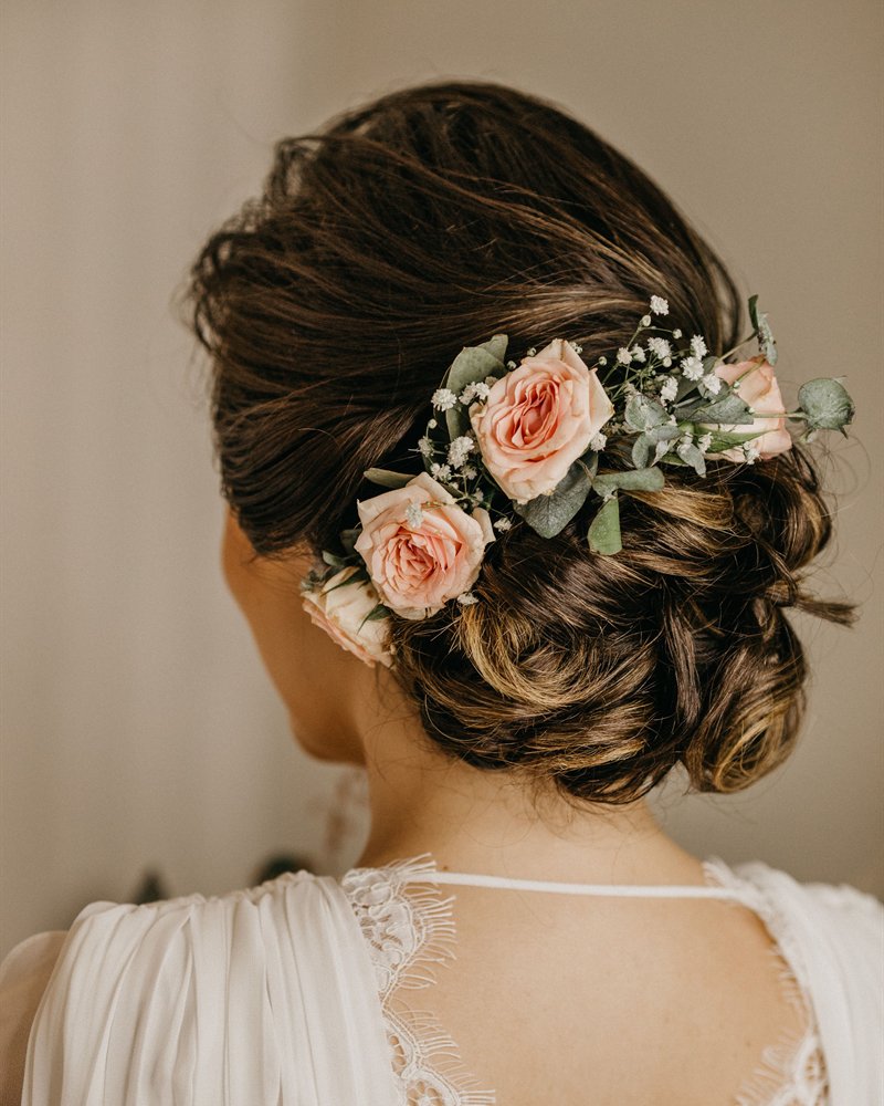 A bridal updo dressed with soft roses