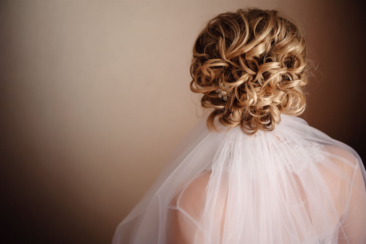 A soft curled bridal updo with veil
