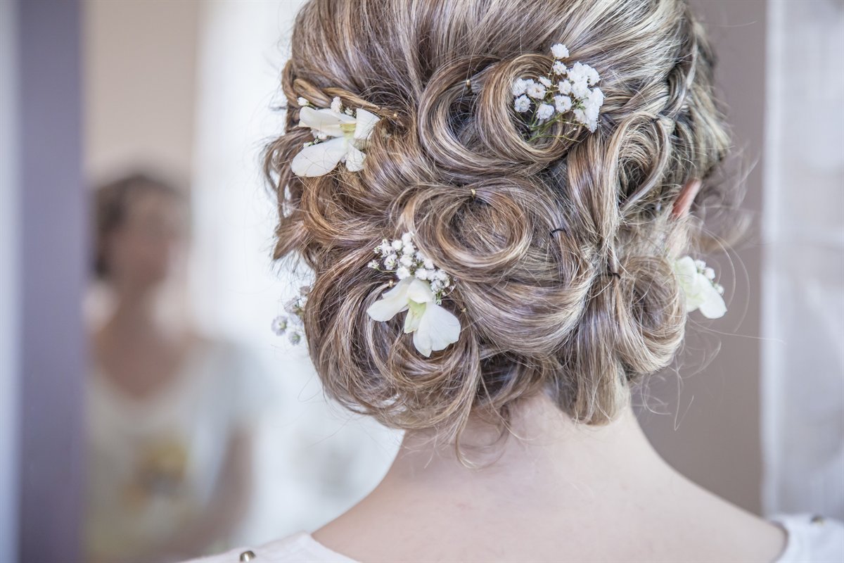 A bridal updo finished with delicate flowers