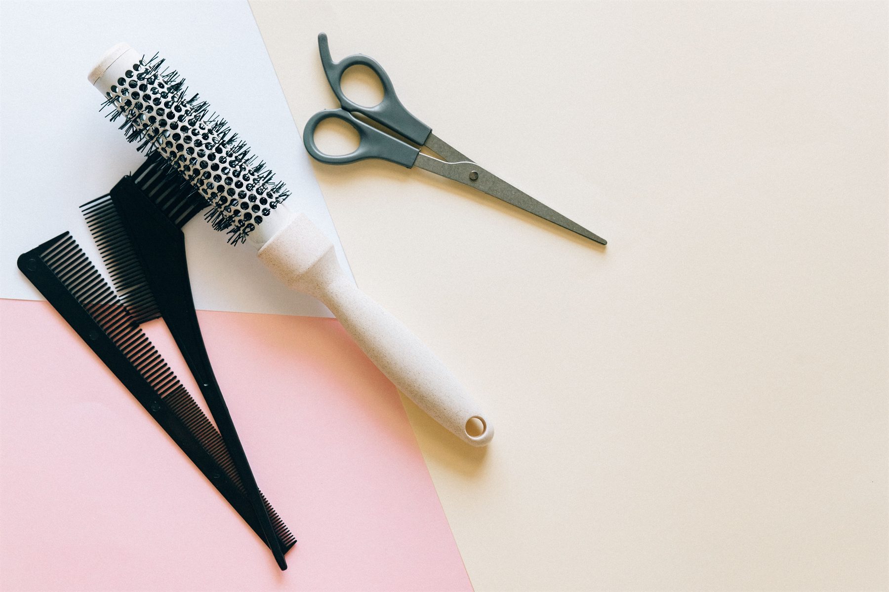 Styling tools arranged on a soft blush flat-lay